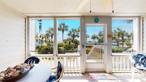 A covered outdoor area with a table, chairs, and a basket of seashells. - Beach Club Villa-Oceanviews in Wild Dunes- community pool & screened porch! (Isle of Palms)