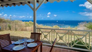 An outdoor dining area with a view of the ocean. - Sea-view villa with pool jacuzzi – sleeps 8 (Les Anses-d´Arlet)