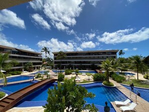 A resort with multiple swimming pools, palm trees, and a large building with balconies. - Malawi Slin Resort Muro Alto (Ipojuca)