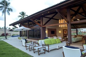 An outdoor patio area with seating, umbrellas, and a pool. - Malawi Slin Resort Muro Alto (Ipojuca)