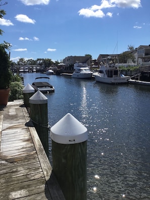 A marina with docked boats, a wooden dock, and a clear blue sky. - Charming Waterfront Cottage: Great summer rental as well as year round! (Freeport)