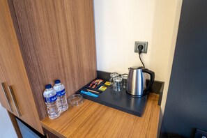 A wooden counter with two water bottles, a kettle, a tray with snacks, and glasses. -  Orange Hotel & Spa (Istanbul)