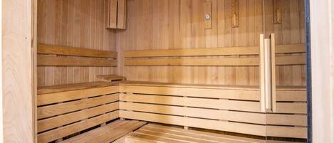 Una sauna de madera con bancos y una puerta.