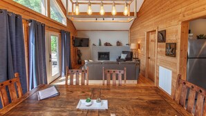 A wooden cabin interior with a dining area, kitchen, and living space. - Stackstone Ridge- Gorgeous View! (Bryson City)