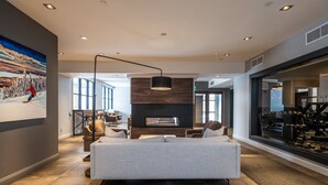 Ein modernes Wohnzimmer mit einer großen Couch, einem Kamin und einem Wandbild mit Ski-Motiv.