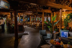 Een gezellig interieur met houten balken, een bar en diverse zithoeken.
