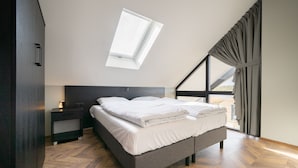 Un dormitorio moderno con tragaluz, una cama, una mesita de noche y vistas al exterior.