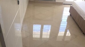 Un pasillo con piso de baldosas brillantes que conduce a un dormitorio.