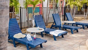 Outdoor seating with blue chairs and a round table, surrounded by palm trees and a colorful mural. - 129 · ☀Pool✔ Kitchen✔ Beach✔ Self Checkin✔ Free Parking✔ (Clearwater)