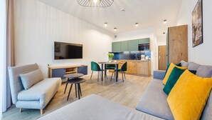 Una sala de estar moderna con un sofá, una mesa de centro y un televisor montado en la pared.