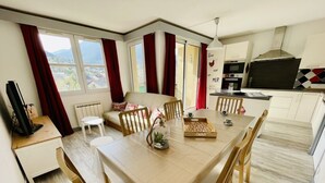 A modern kitchen with a dining area, large windows, and a view of the mountains. - Bright 50 M² With Balcony And View On The Valley (Briançon)