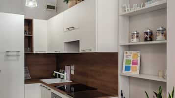 A modern kitchen with white cabinets, a wooden countertop, and a dining table.