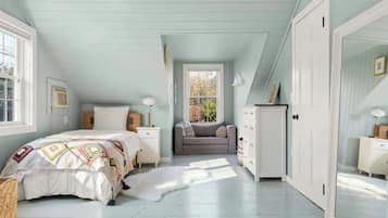 A bedroom with a bed, a dresser, a chair, and a window.