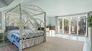 A spacious bedroom with a four-poster bed, a large window, and a view of the outdoors. - Stylish Mid-century Modern Berkshires Cape (Lee)