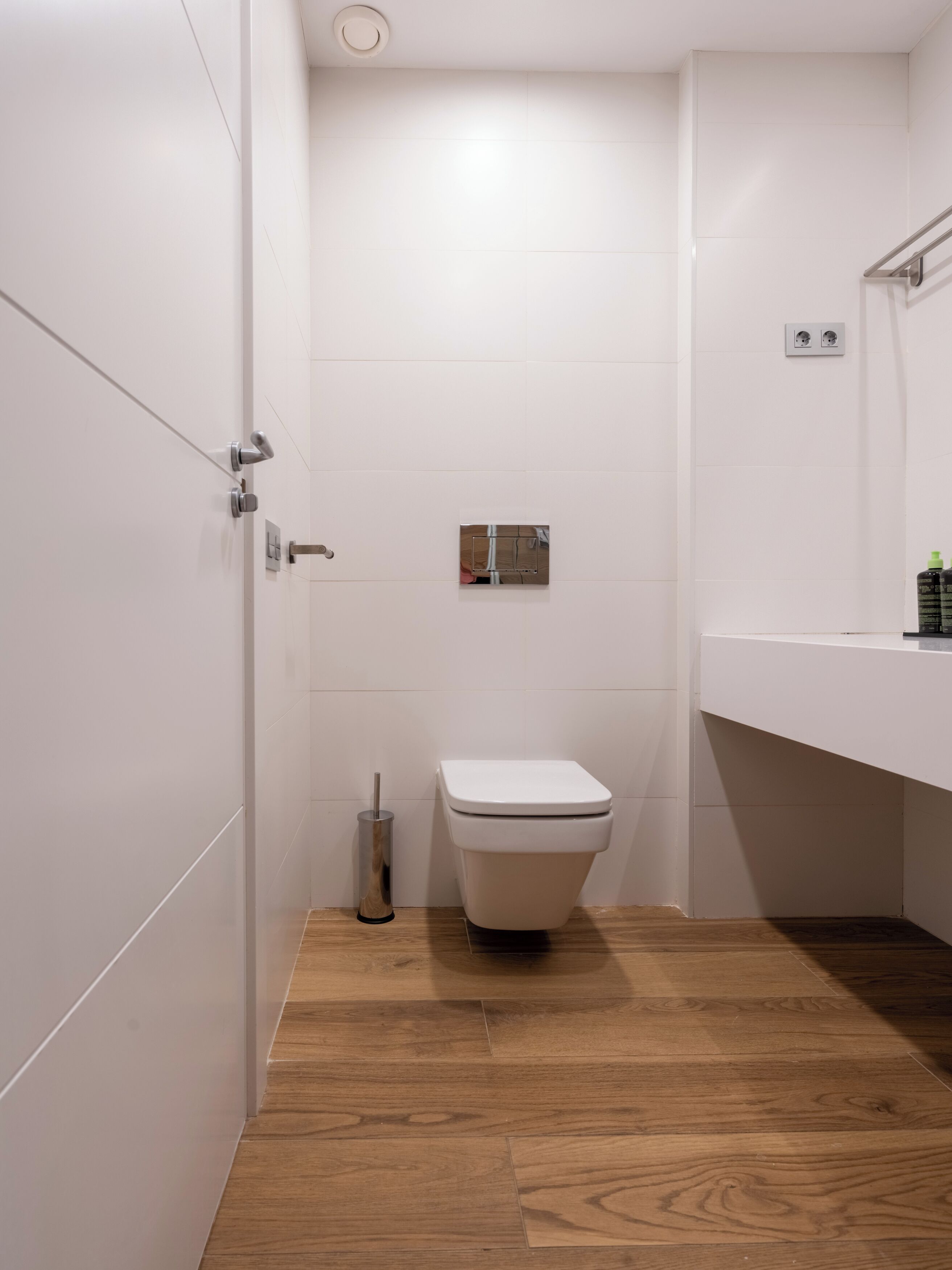 Un baño moderno con inodoro, secamanos y lavamanos.