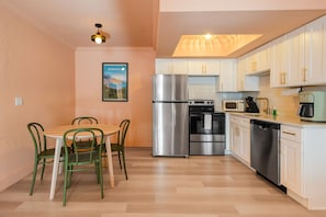 A compact kitchen with a refrigerator, oven, microwave, and dishwasher.