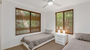 Relax in this serene bedroom with a single bed, nightstand, and two lamps.