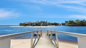 A waterfront property with a dock leading to a sandy beach. - Driftwood 5 Noosaville (Noosaville)