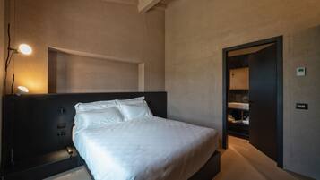 A modern bedroom with a large bed, bedside lamps, and a built-in wardrobe.