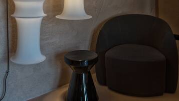 A modern interior with a wall-mounted light fixture and a round black table.