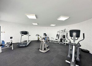 A gym with treadmills, elliptical machines, and weight equipment.