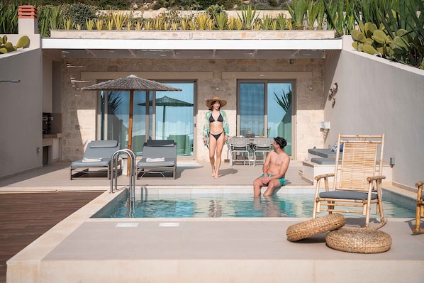A modern outdoor pool area with lounge chairs, a table, and a dining area. - Villa Vista I Free Heated Pool Dazzling Seaview (Kissamos)