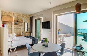 A modern hotel room with a bed, a desk, a chair, a round table, and a balcony with a view. - Villa Vista I Free Heated Pool Dazzling Seaview (Kissamos)
