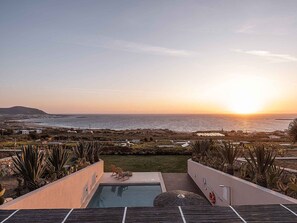 A pool with a view of the ocean at sunset, surrounded by cacti and a small seating area. - Villa Vista I Free Heated Pool Dazzling Seaview (Kissamos)
