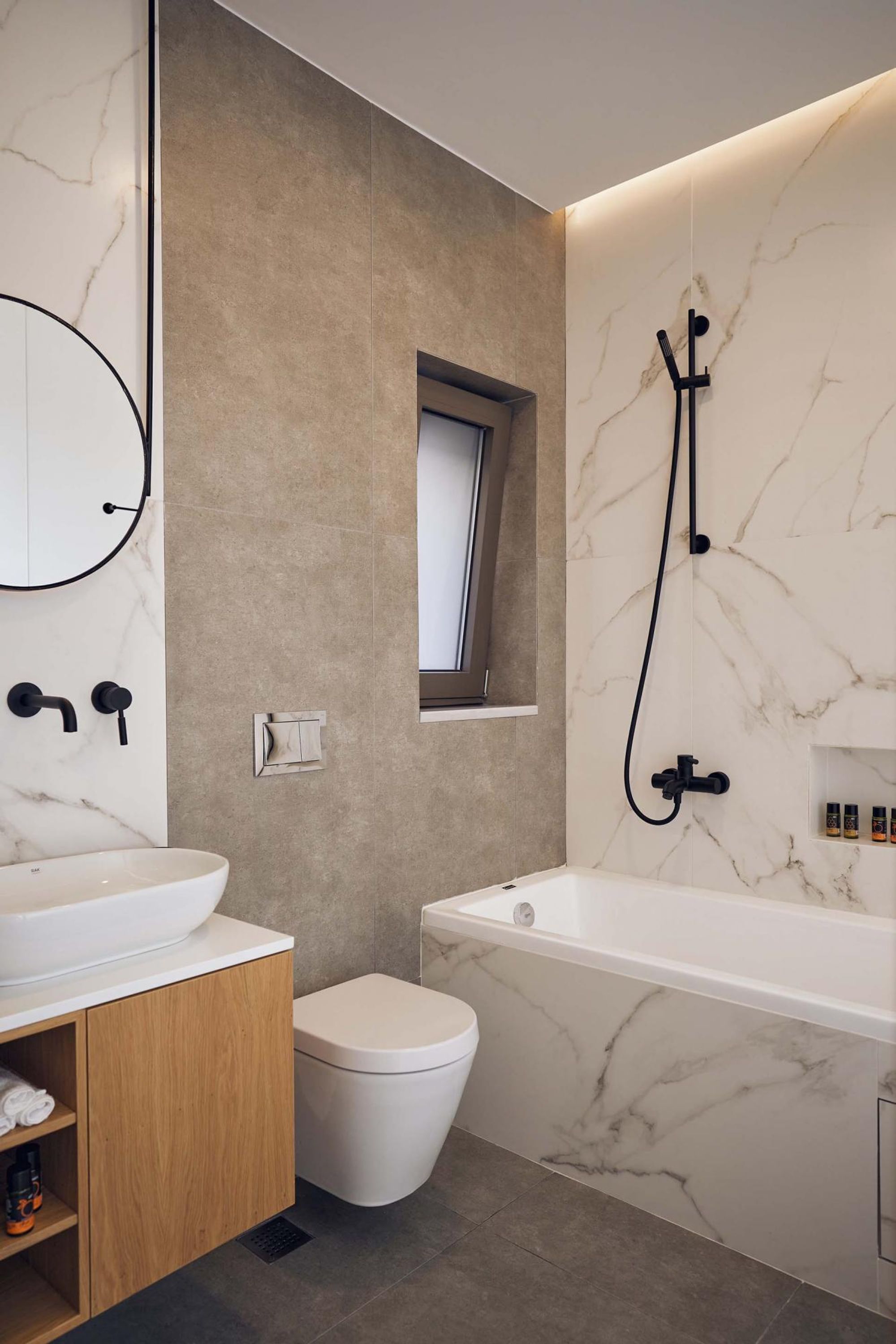 Une salle de bain moderne avec un lavabo en marbre, des toilettes et une baignoire.