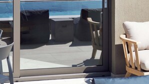 A modern balcony with a glass door, overlooking a coastal view. - Omnia Villa I - Heated Pool Stunning Seaview (Chania)