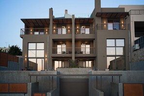 Un immeuble à plusieurs étages doté de balcons, de grandes fenêtres et d’une entrée de garage.