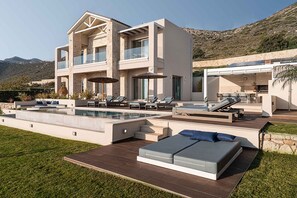A modern two-story house with a swimming pool, outdoor seating, and a view of the mountains. - Villa Mare I Free Heated Pool Infinite Blue (Kissamos)