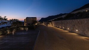 A wooden pathway leading to a building with stone walls, under a twilight sky. - Villa Mare I Free Heated Pool Infinite Blue (Kissamos)
