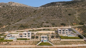 A hillside property with modern houses, a swimming pool, and a clear view of the surrounding landscape. - Villa Mare I Free Heated Pool Infinite Blue (Kissamos)