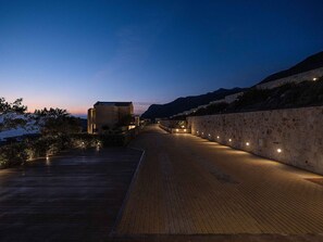 A wooden pathway leading to a building with stone walls, under a twilight sky. - Villa Mare I Free Heated Pool Infinite Blue (Kissamos)