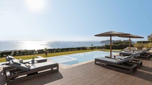 A poolside area with lounge chairs, a small pool, and a view of the sea. - Villa Mare I Free Heated Pool Infinite Blue (Kissamos)