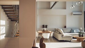 Un salon moderne avec un escalier, un coin repas et un canapé.