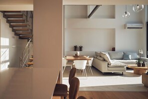 Una sala de estar moderna con una escalera, un comedor y un sofá.