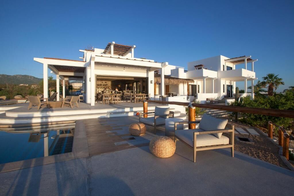 Eine moderne Villa mit Pool, Sitzgelegenheiten im Freien und einem Restaurant.