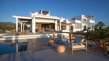 Eine moderne Villa mit Pool, Sitzgelegenheiten im Freien und einem Restaurant.