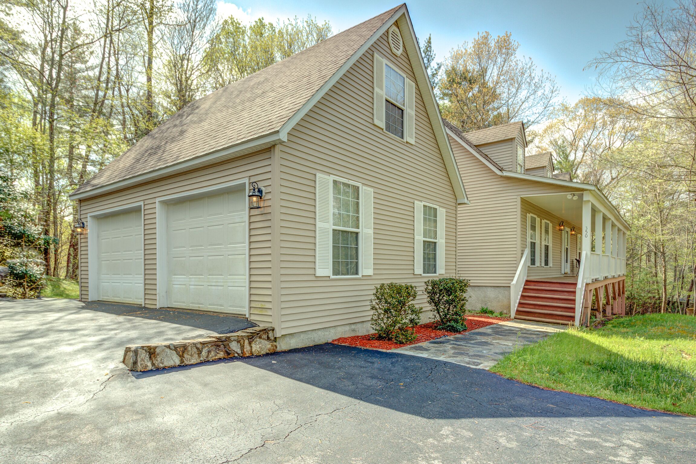 A single-story house with a garage, a front porch, and a small front yard with landscaping.