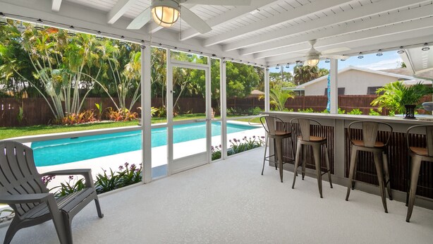 A covered patio area with a pool, outdoor seating, and a bar. - Mermaid Shack with pool 5 min to beach,venues,restaurants (Jupiter)
