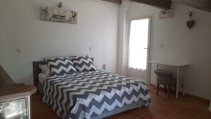 Quarto com cama, escrivaninha e cadeira.