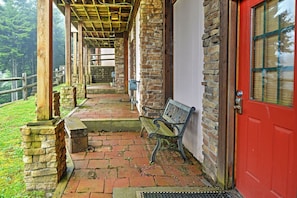 Step out onto the covered porch, where a bench invites you to sit and take in the surroundings.