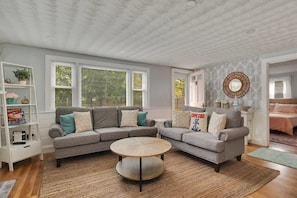 A living room with a sectional sofa, a round coffee table, and a bookshelf. - Perfect House In Yarmouth, Book Now & Come Relax! (Yarmouth)