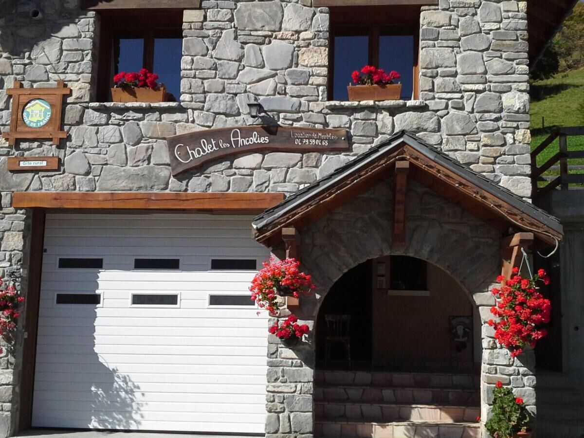 Ein Steinhaus mit einem Schild, auf dem 'Chalet des Ancolies' steht.