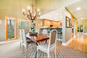 A dining area with a wooden table, chairs, and a chandelier.