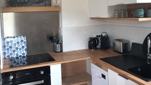Eine kleine Küche mit Geschirrspüler, Kaffeemaschine und Toaster.