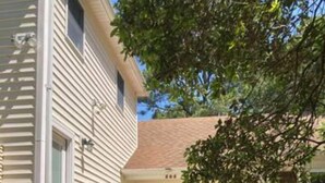 A two-story house with a wooden deck and a small staircase leading to the front door. - OBX gem, private studio, couple's nest!  (Kill Devil Hills)