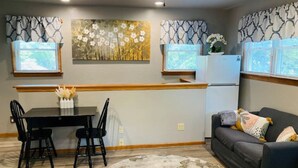 A compact living space with a dining area, a sofa, and a kitchen area. - OBX gem, private studio, couple's nest!  (Kill Devil Hills)